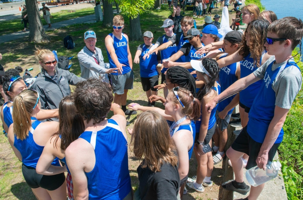 Rowing team getting ready to do a cheer--hands in!