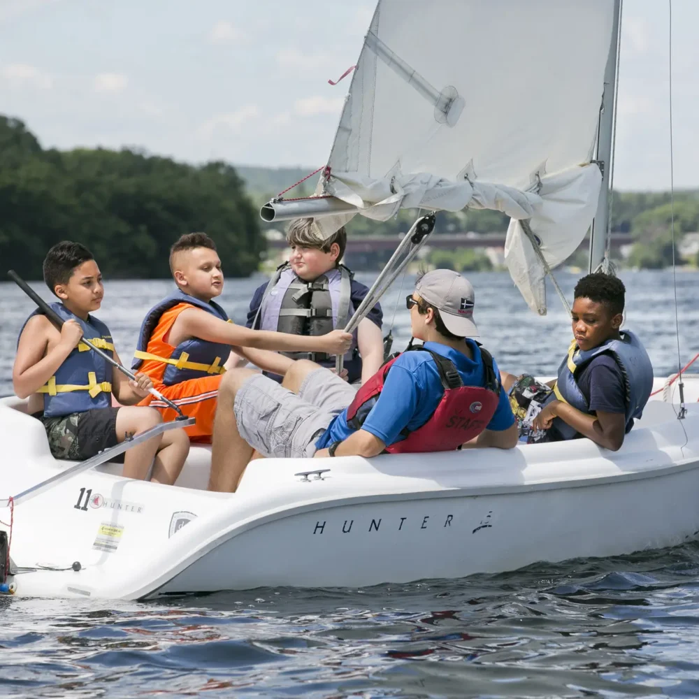 Group of kids in a sailboat with instructor