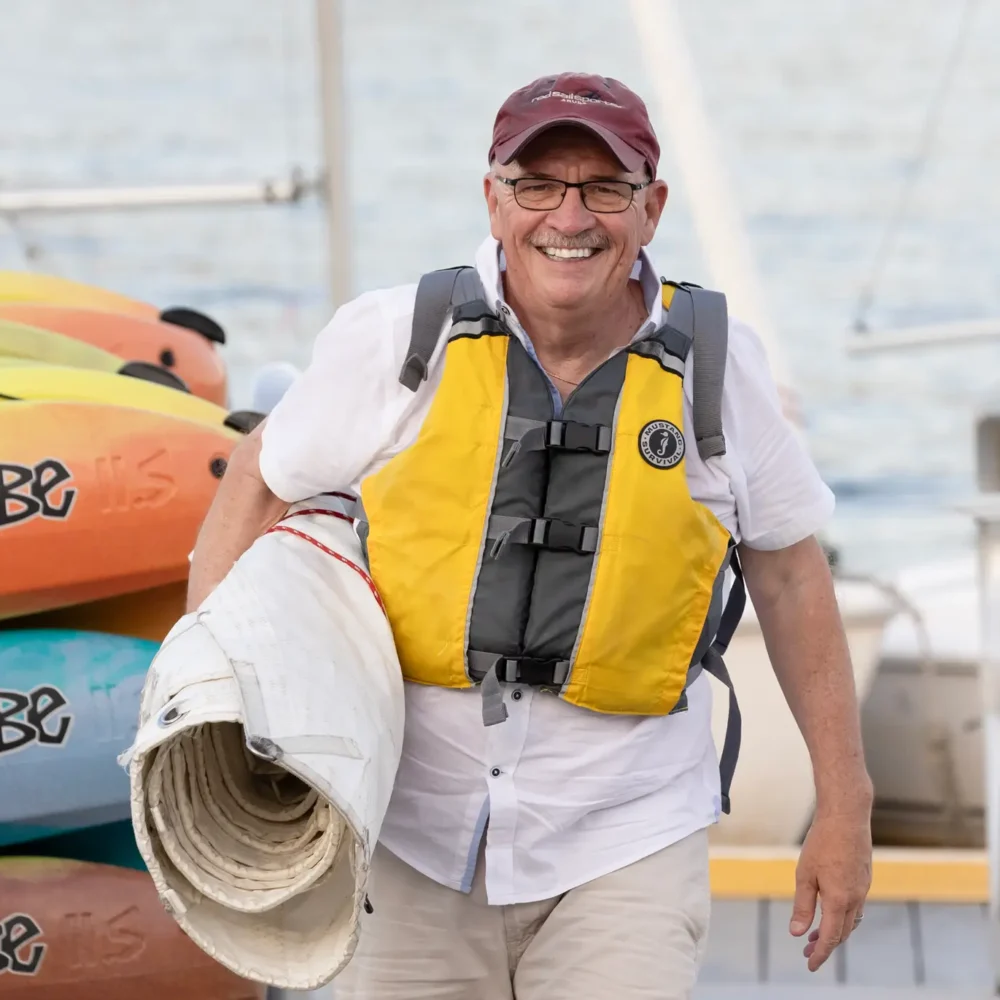 Man carrying rolled up sail during Regatta Point Adult Sailing Class