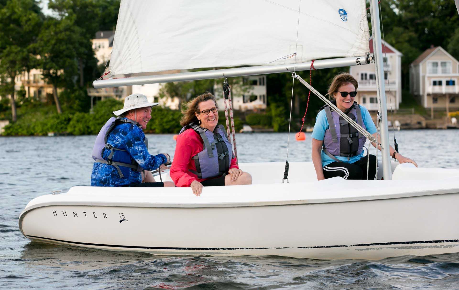 three adults on a sailboat