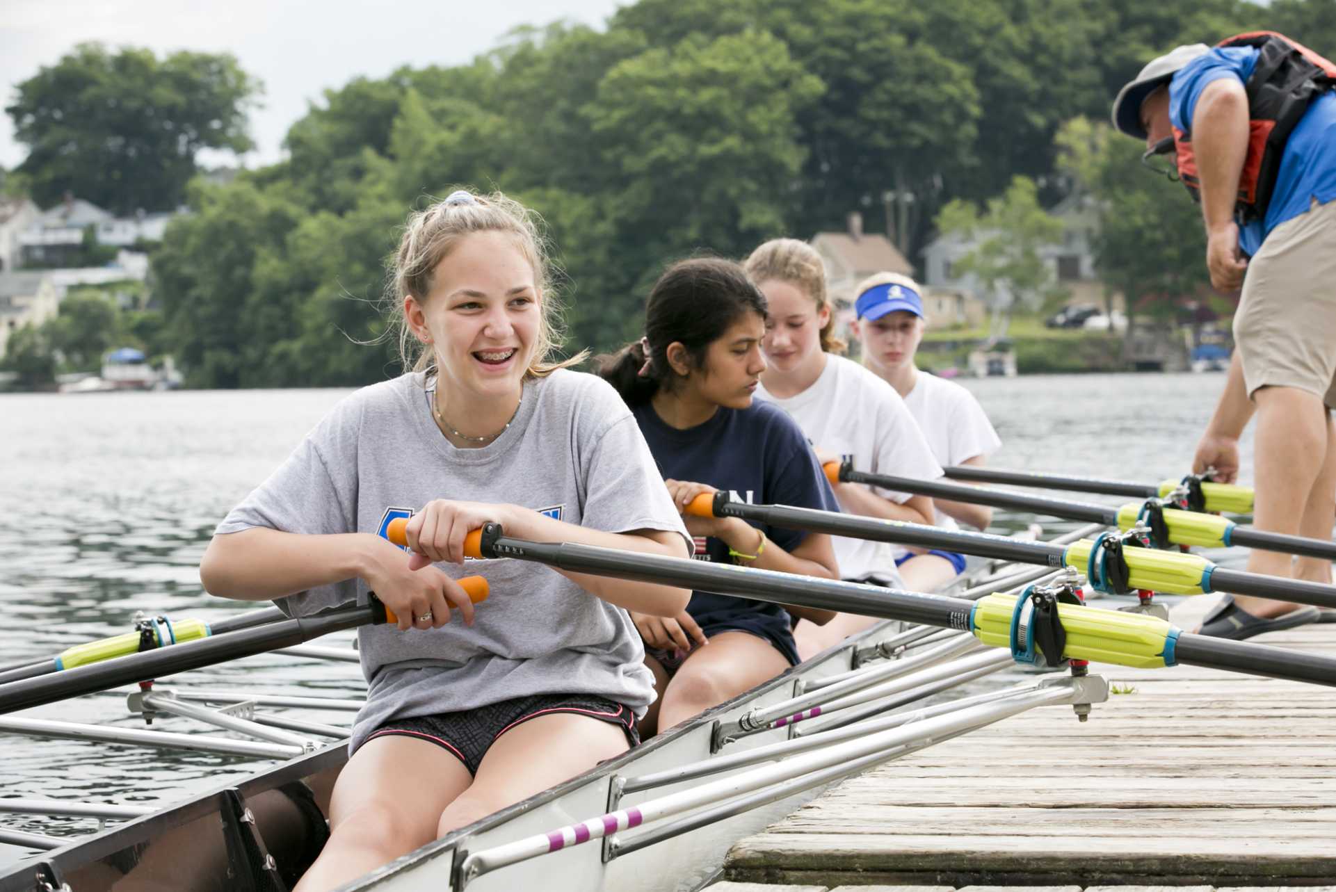 four teenagers in a rowing shell